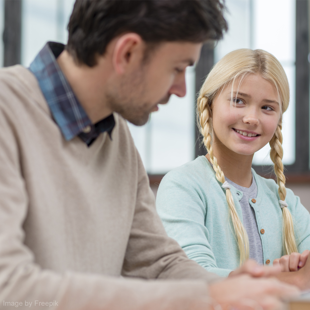 Ein Sozialarbeiter in einem Gespräch mit einem Kind.